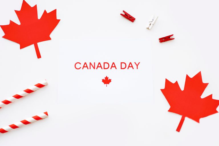Festive Canada Day arrangement featuring red maple leaf decorations on a white background.