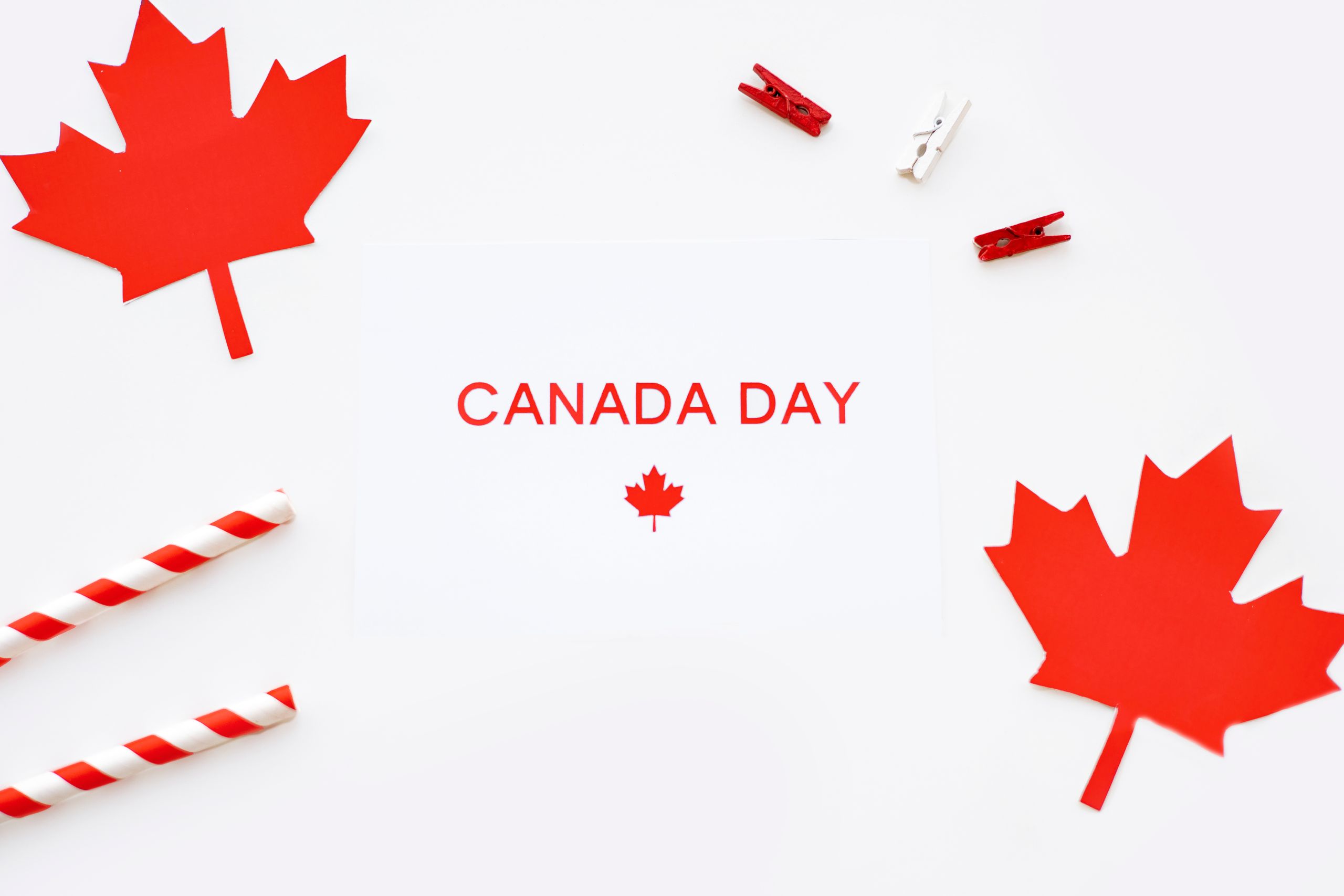 Festive Canada Day arrangement featuring red maple leaf decorations on a white background.